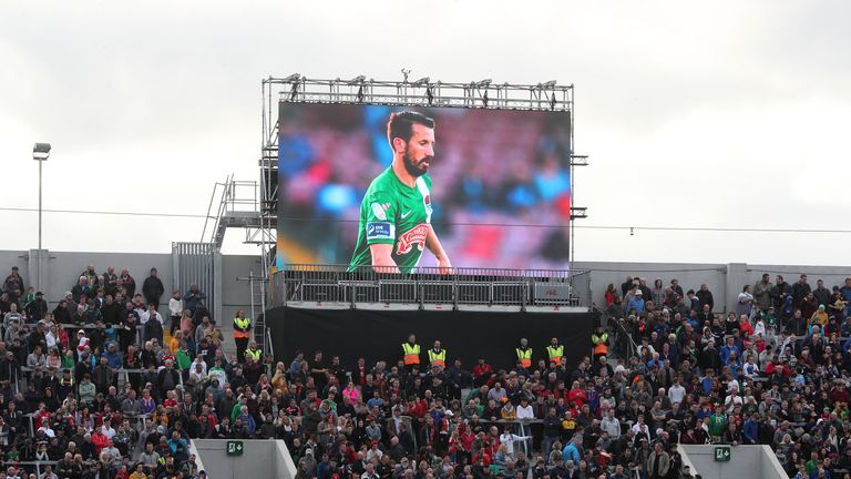 A tribute screen displaying photographs of Liam Miller above the stands during his Tribute Match.