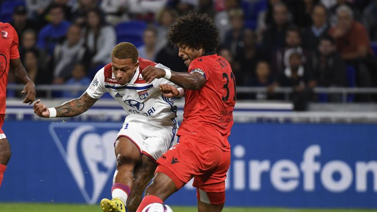 Lyon's Memphis Depay shoots on goal under pressure from Dante of OGC Nice