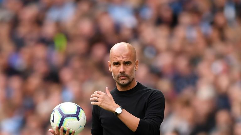 Manchester City boss Pep Guardiola holding ball on the touchline