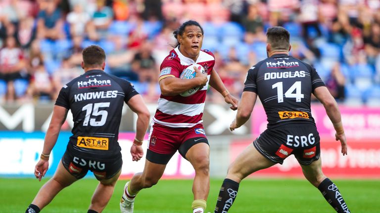 Wigan's Taulima Tautai takes on St Helens' Morgan Knowles and Luke Douglas