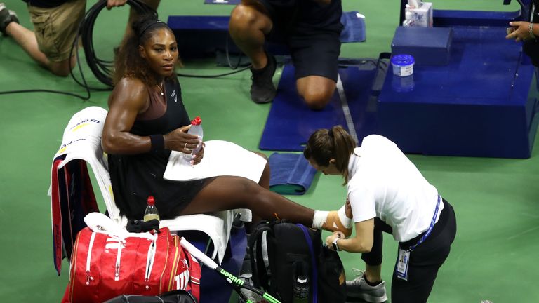 Serena Williams receives treatment on her ankle during her game against sister Venus at the US Open