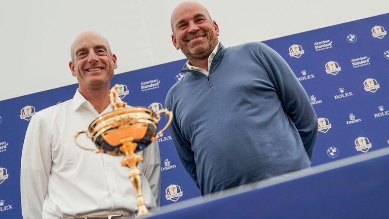Ryder Cup team captains, Europe's Thomas Bjorn (R) and US Jim Furyk, pose in front of the Ryder Cup trophy