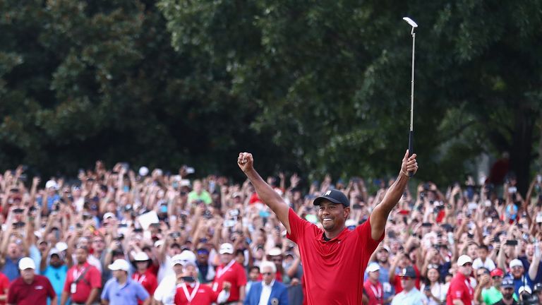 Tiger Woods celebrates after holing his final putt on the 18th green