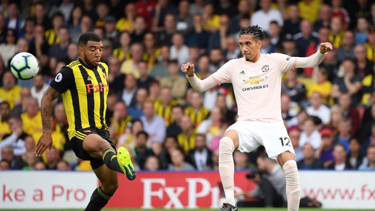 Troy Deeney of Watford (L) challenges for the ball with Chris Smalling of Manchester United during the Premier League match between Watford FC and Manchester United at Vicarage Road on September 15, 2018 in Watford, United Kingdom