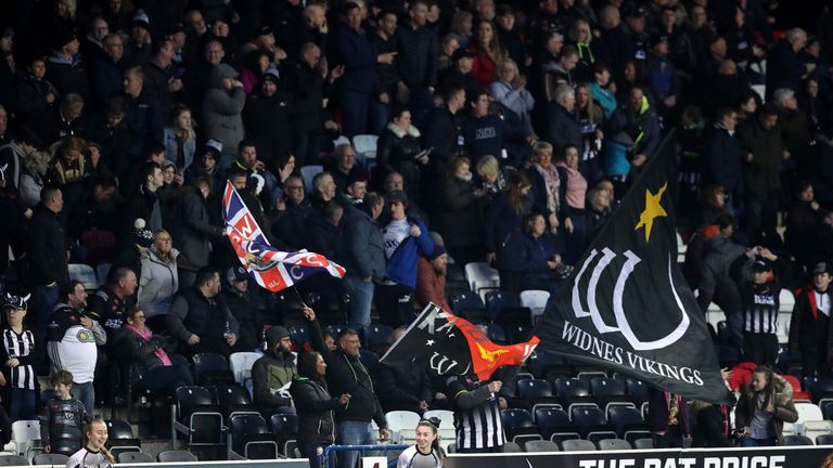 Widnes Vikings fans in the stands wave flags 