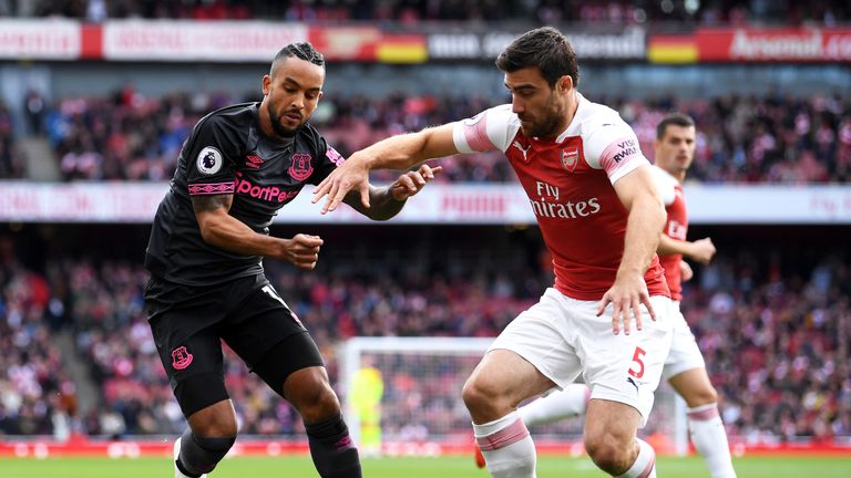 Sokratis and Theo Walcott battle for the ball