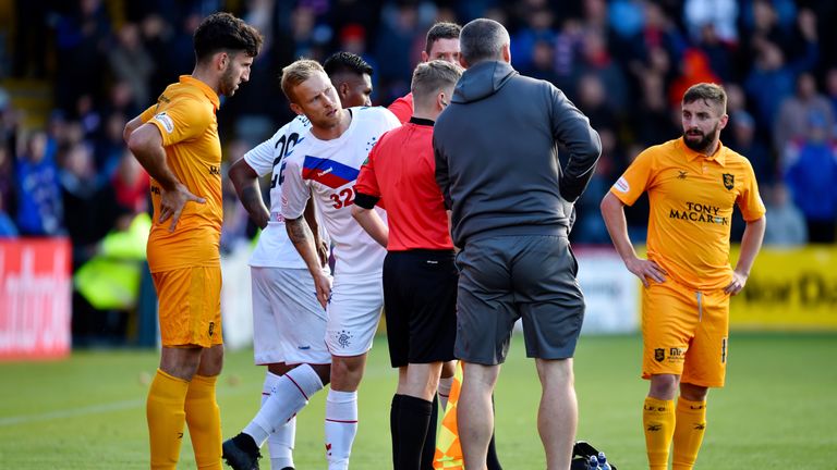 Calum Spence receives treatment as Rangers' Scott Arfield looks on