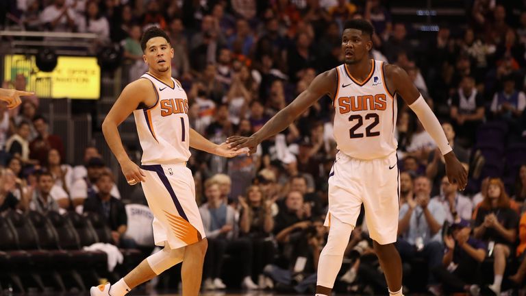 Devin Booker #1 and Deandre Ayton #22 of the Phoenix Suns high five after scoring against the Dallas Mavericks during the second half of the NBA game at Talking Stick Resort Arena on October 17, 2018 in Phoenix, Arizona.