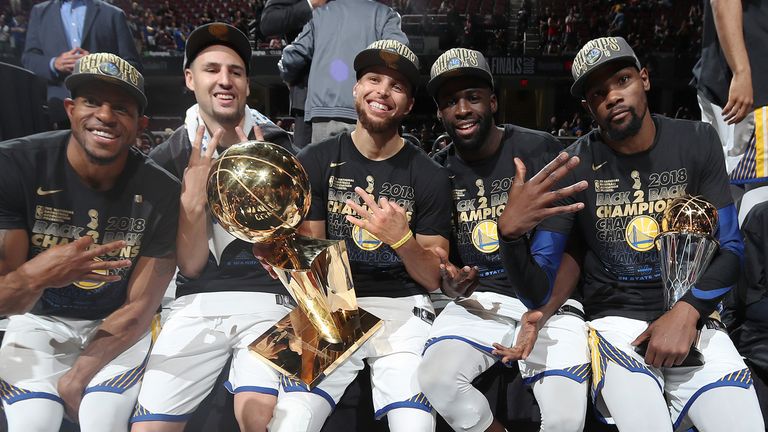 Andre Iguodala #9, Klay Thompson #11, Stephen Curry #30, Draymond Green #23, and Kevin Durant #35 of the Golden State Warriors pose with the Larry O'Brien Championship Trophy after Game Four of the 2018 NBA Finals against the Cleveland Cavaliers on June 8, 2018 at Quicken Loans Arena in Cleveland, Ohio.