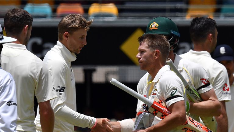 Australia's batsman David Warner (R) shakes hands with England's skipper Joe Root at the end of first cricket Ashes Test between England and Australia in Brisbane on November 27, 2017.