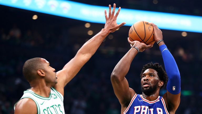 Joel Embiid shoots while guarded by Al Horford
