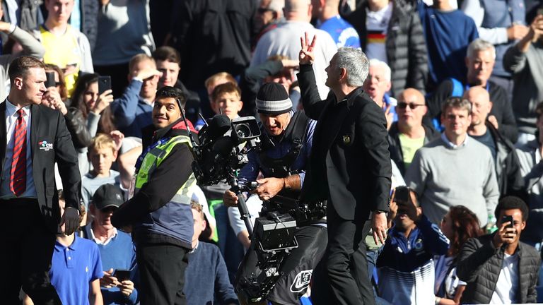 Jose Mourinho holds up three fingers as he gestures towards fans