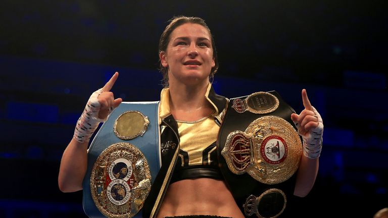 Taylor hoists the WBA and IBF belts after her most recent win against Kimberly Connor