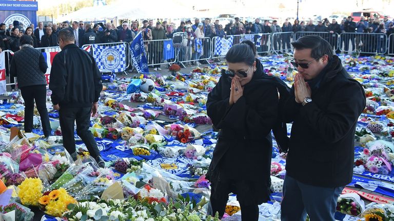 Aiyawatt (R) and Aimon (L), the son and wife of Leicester City's Thai chairman Vichai Srivaddhanaprabha who died in a helicopter crash at the club's stadium, pray after laying wreathes among the tributes to the victims of the crash.