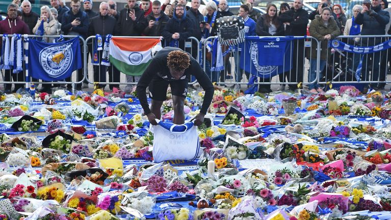 Leicester City youth team player Darnell Johnson lays a football shirt among floral tributes left to the victims of the helicopter crash which killed Leicester City's Thai chairman Vichai Srivaddhanaprabha.