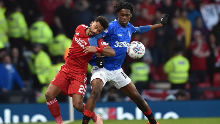 Aberdeen's Shay Logan (L) competes with Rangers' Ovie Ejaria