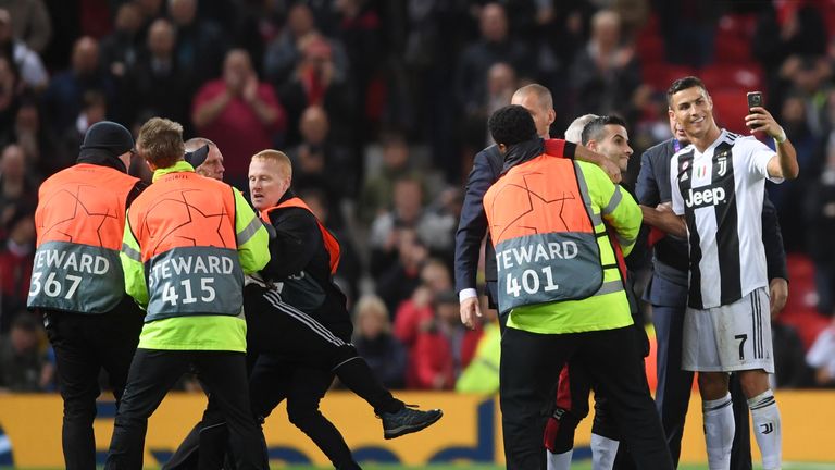 Cristiano Ronaldo takes a selfie with a pitch invader