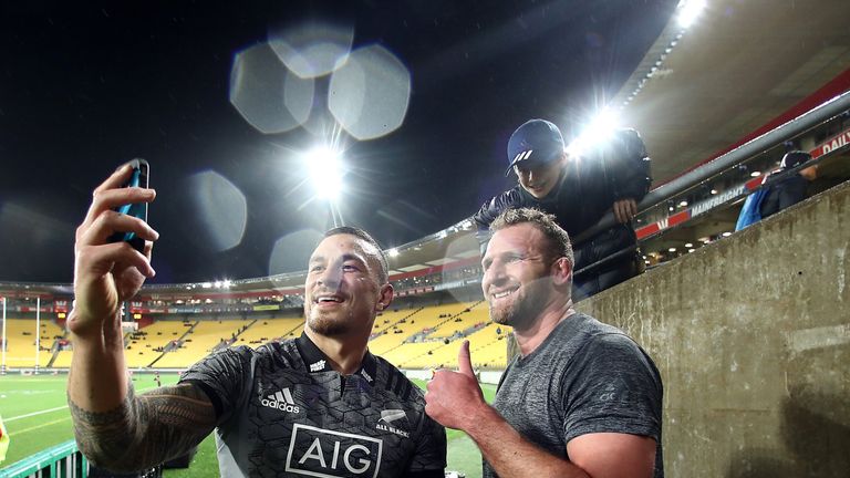 Sonny Bill Williams and Kieran Read post with a fan after an All Blacks match