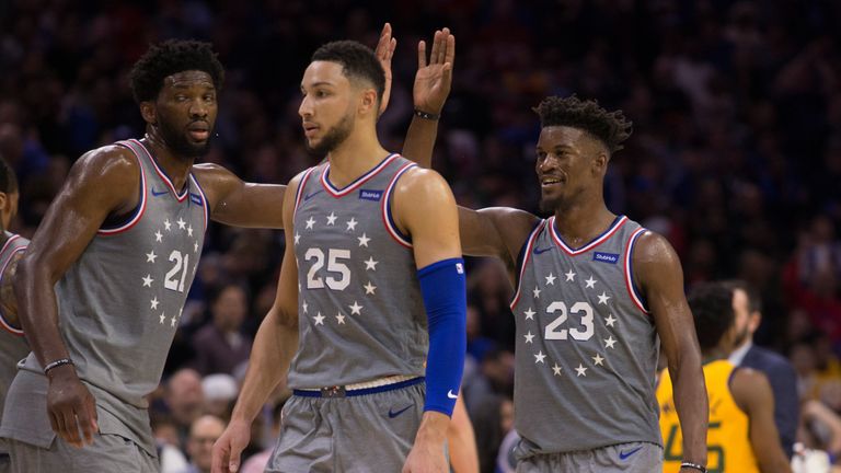 Joel Embiid high-fives team-mate Jimmy Butler