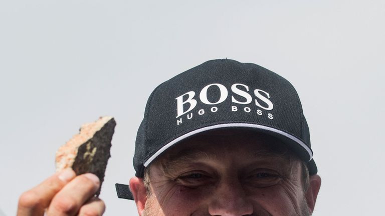 Alex Thomson shows part of the damaged hull of his boat