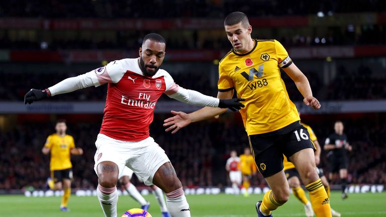 Alexandre Lacazette battles for possession with Conor Coady