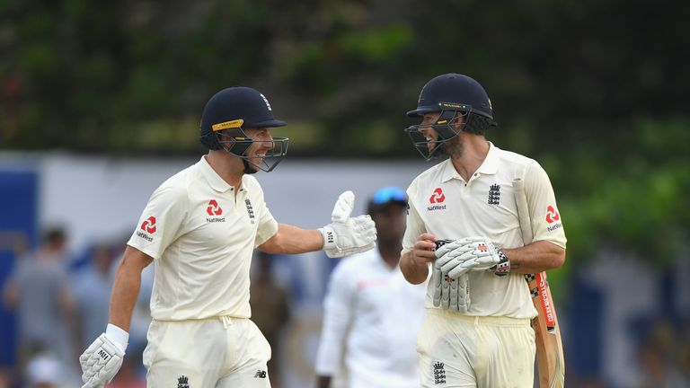 Foakes (right) is congratulated by not-out partner Jack Leach as the pair leave the field with England 321-8