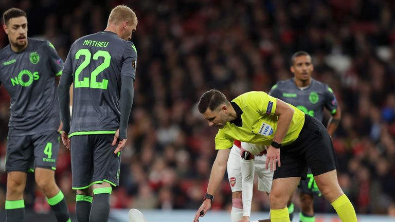 Referee Gediminas Mazeika stands over Danny Welbeck of Arsenal as he is injured during the UEFA Europa League Group E match between Arsenal and Sporting CP at Emirates Stadium on November 8, 2018 in London, United Kingdom.