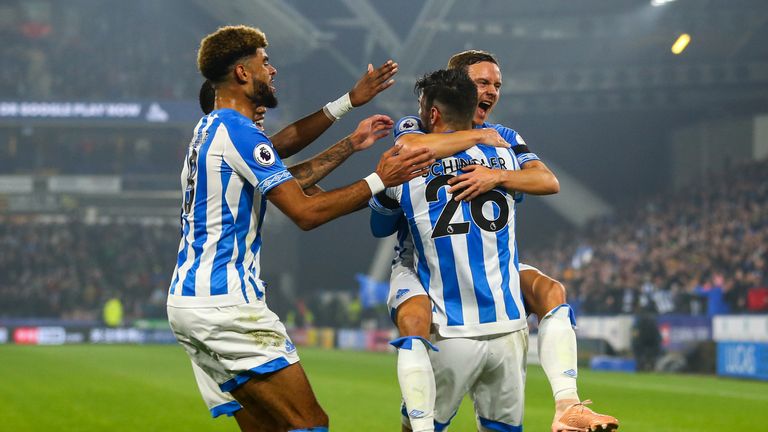 Huddersfield players celebrate after Timothy Fosu-Mensah's own-goal