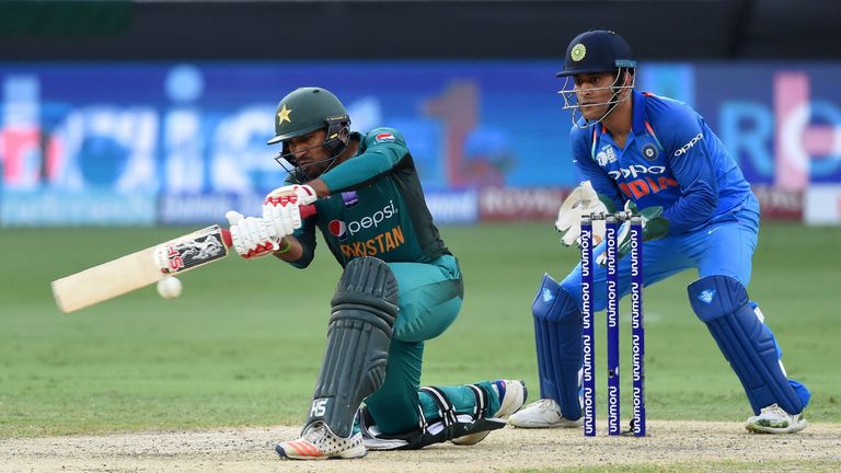 Pakistan's captain Sarfraz Ahmed plays a shot as Indian wicketkeeper Mahendra Singh Dhoni (R) looks on during the one day international (ODI) Asia Cup cricket match between Pakistan and India at the Dubai International Cricket Stadium in Dubai on September 23, 2018.