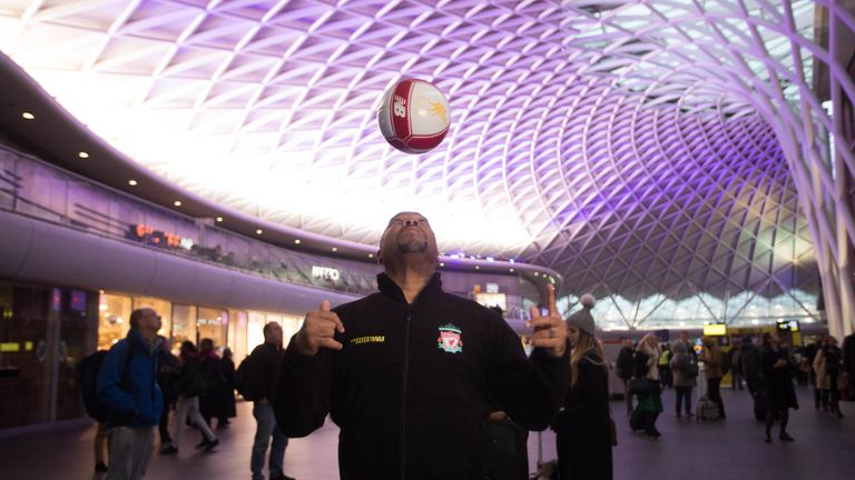 Former Liverpool FC player John Barnes teaches commuters how to perfect striking a football at a pop-up event hosted by Western Union at Kings Cross station in London.