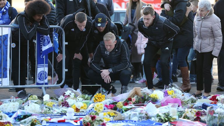 Leicester City goalkeeper Kasper Schmeichel and team-mates Hamza Choudhury and Marc Albrighton, look at the tributes to former owner Vichai Srivaddhanaprabha outside the King Power Stadium