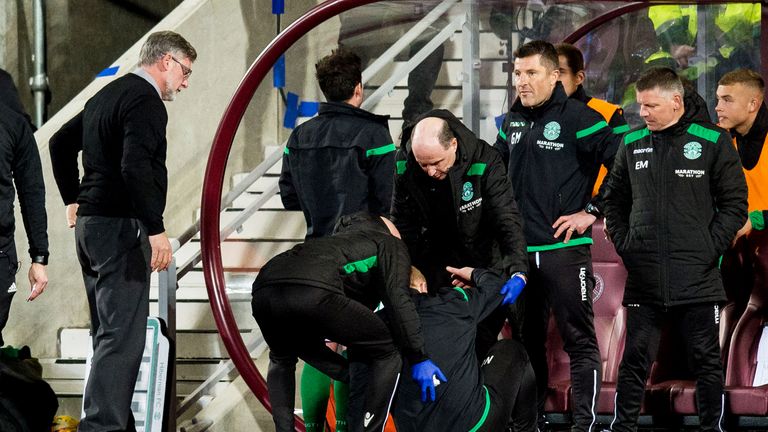 Hibernian manager Neil Lennon is helped to his feet after appearing to be struck by an object from the crowd