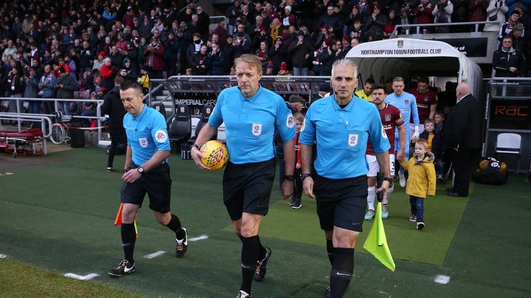 Referee Trevor Kettle and his assistants Paul Kelly (L) and Ravel Cheosiaus lead out the teams wearing Rainbow Laces during the Sky Bet League Two match between Northampton Town and Grimsby Town at Sixfields on November 24, 2018 in Northampton, United Kingdom