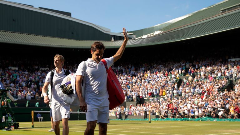 Roger Federer and Kevin Anderson leave the court at Wimbledon