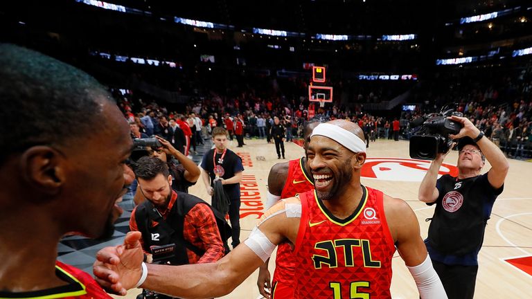 Vince Carter #15 of the Atlanta Hawks reacts with Dewayne Dedmon #14 after scoring his 25,000th NBA point in the final seconds of their 124-108 loss to the Toronto Raptors at State Farm Arena on November 21, 2018 in Atlanta, Georgia. 