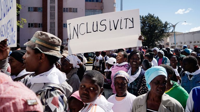 A demonstrator holds a placard on July 19, 2018 as she takes part in a march for peace organised by Churches Convergence on Peace Project, ahead of the Zimbabwe elections in Bulawayo, Zimbabwe