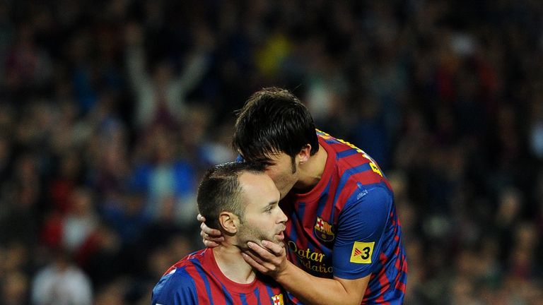 Andres Iniesta (L) of FC Barcelona sits on his knees in the penalty aeria as he reacts with his teammate David Villa after being fouled, for which referee Eduardo Iturrald gave a penalty, during the la Liga match between FC Barcelona and Sevilla FC at the Camp Nou stadium on October 22, 2011 in Barcelona, Spain. 
