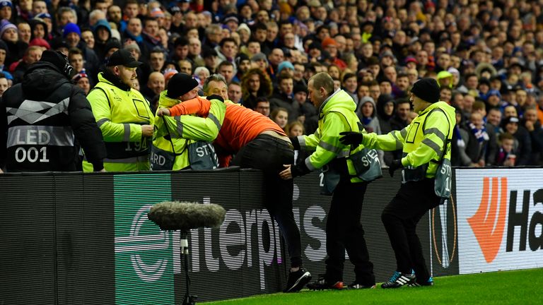A fan is led away by stewards during Rangers' Europa League game against Villarreal