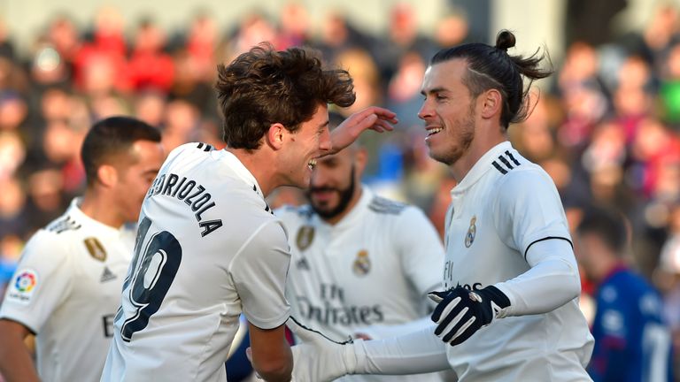 Real Madrid's Welsh forward Gareth Bale (R) is congratulated by teammate defender Alvaro Odriozola after scoring his team's first goal during the Spanish league football match between SD Huesca and Real Madrid CF at the El Alcoraz stadium on December 9, 2018