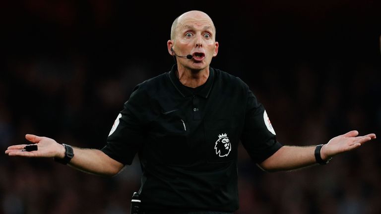 Referee Mike Dean gestures during the north London derby at the Emirates Stadium
