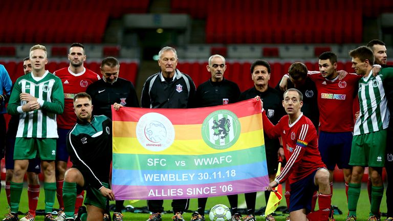 The teams pose for a photo with a rainbow flag prior to kiock-off in the Middlesex County Football League Division One match between Stonewall FC and AFC Wilberforce at Wembley Stadium on November 30, 2018 in London, England