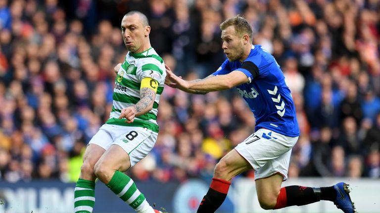 Celtic captain Scott Brown clears the ball from Rangers Scott Arfield