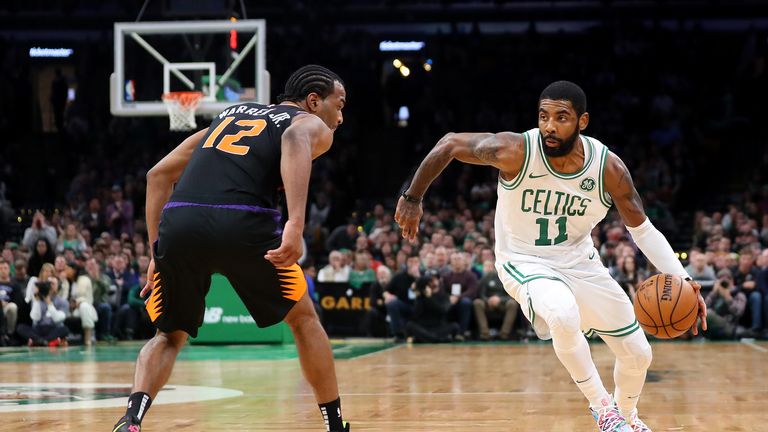 T.J. Warren of the Phoenix Suns defends Kyrie Irving of the Boston Celtics