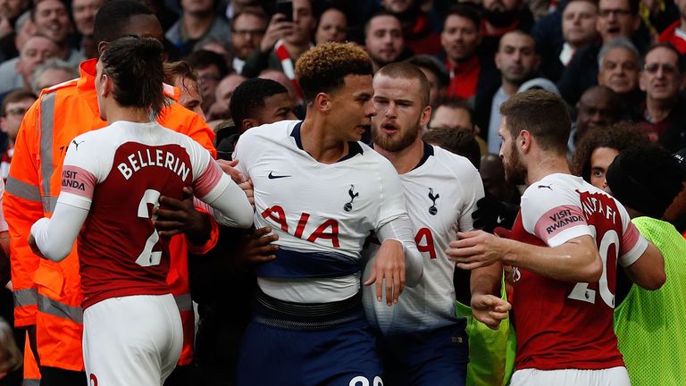 Tottenham Hotspur's English midfielder Dele Alli (C) is restrained after celebrating Dier's equalizer during the English Premier League football match between Arsenal and Tottenham Hotspur at the Emirates Stadium in London on December 2, 2018. 