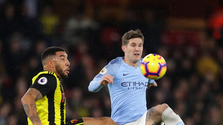 Troy Deeney and John Stones in action at Vicarage Road