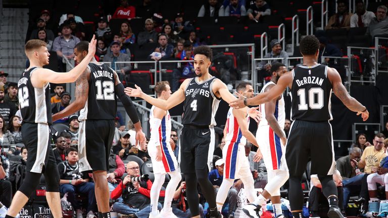 Derrick White high-fives his Spurs team-mates