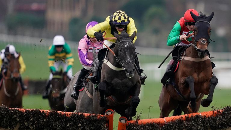 Tom O'Brien riding Elixir De Nutz (yellow) clear the last to win the Unibet Tolworth Novices' Hurdle at Sandown