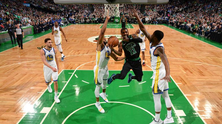 Kyrie Irving tries to finish at the basket with two defenders in his face