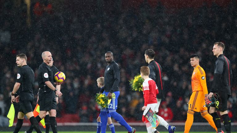 Bamba leads out the Cardiff side holding flowers in honour of Sala
