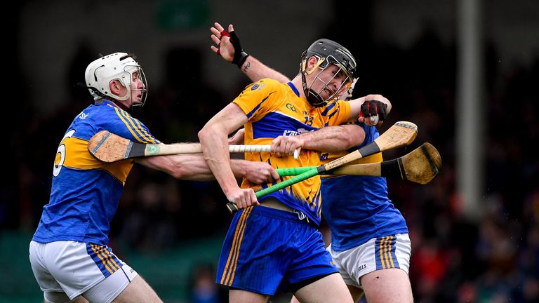 Family ties: Brothers Ronan and Padraic Maher of Tipperary hold up Colin Guilfoyle of Clare